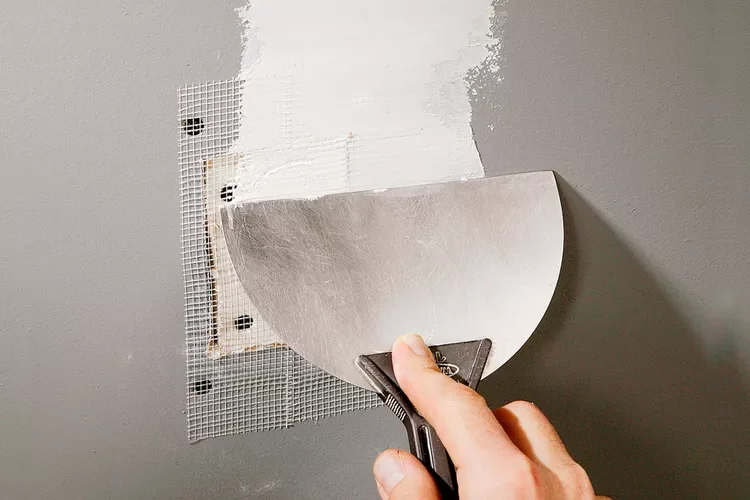 Drywall repair with mesh tape and spatula
